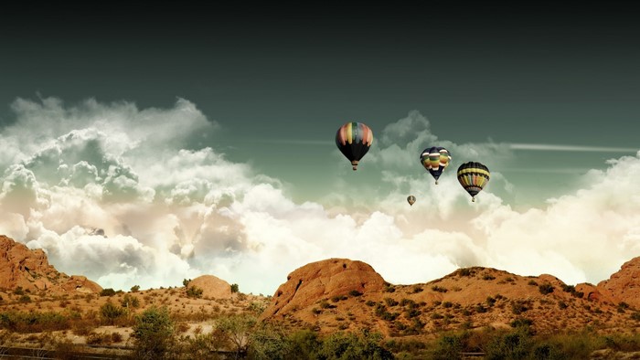 Hot air balloons over desert mountains