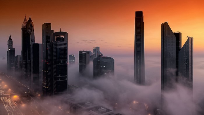 Dubai skyscrapers shrouded in fog at sunset