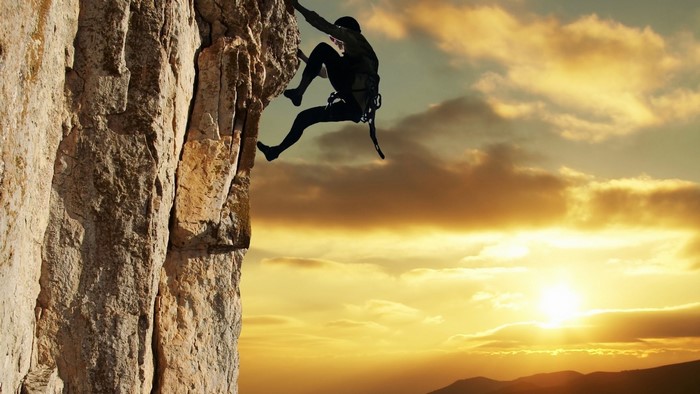 Silhouette of a rock climber at sunset