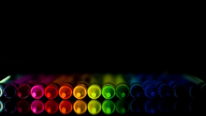 Rainbow colored markers on black background