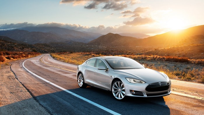 Silver Tesla on a Desert Road at Sunset