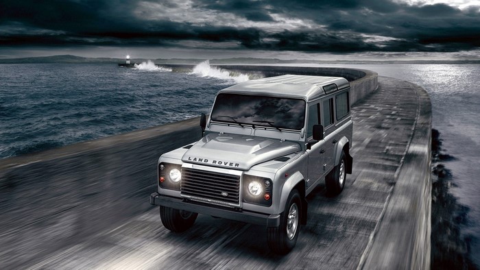 2012 Land Rover Defender driving on a coastal road