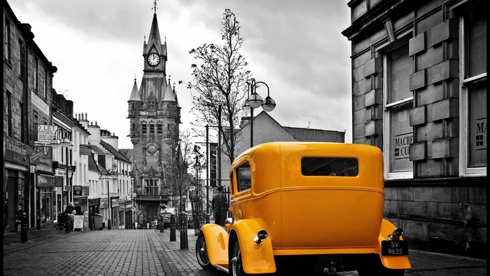 Yellow Hotrod on Cobblestone Street with Clock Tower