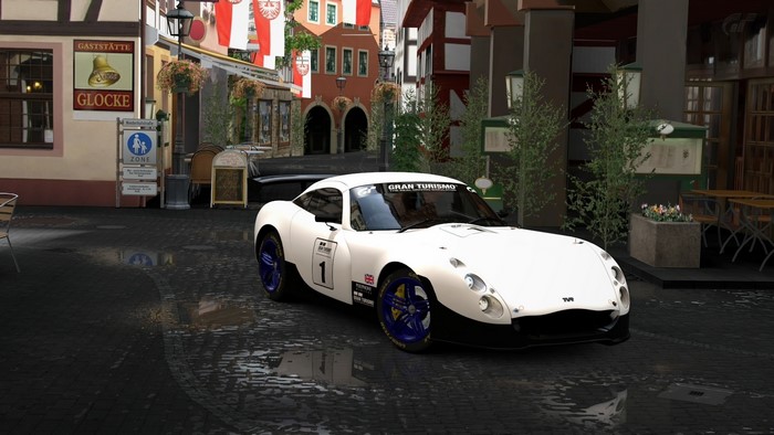 White TVR Gran Turismo 5 race car on wet cobblestone street