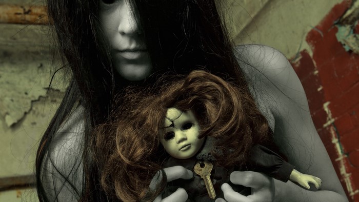 Creepy ghost girl holding a broken doll