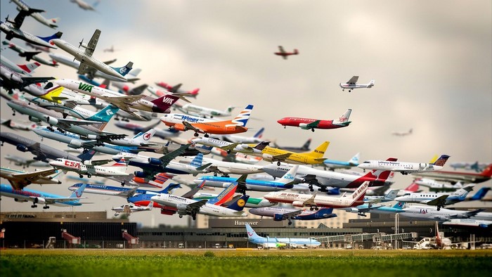 Many airplanes flying over an airport
