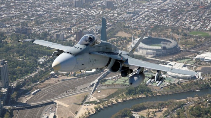 F/A-18 Hornet flying over a city