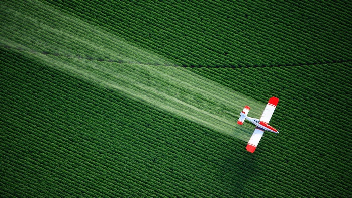 4K Plane Spraying Over Crop Field