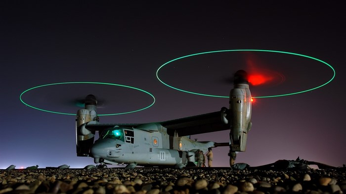 Osprey aircraft with glowing rotors at night