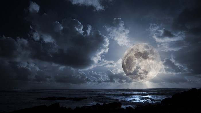 Full moon over the ocean at night