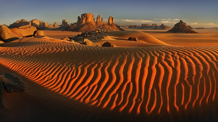Desert landscape with sand dunes and rock formations