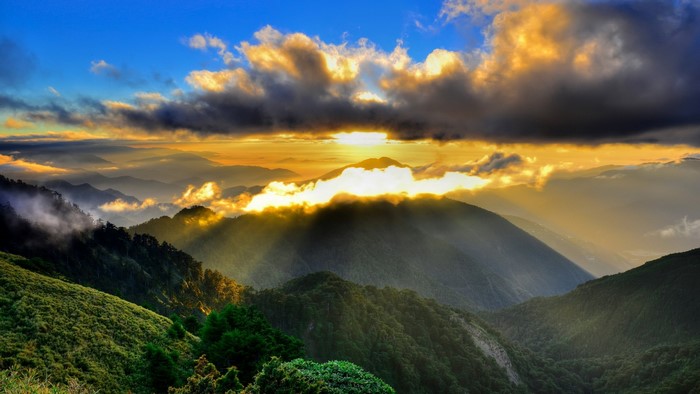 Sunrise over misty mountains with sunbeams