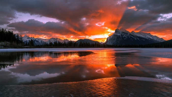 Sunset over a freezing river with mountains