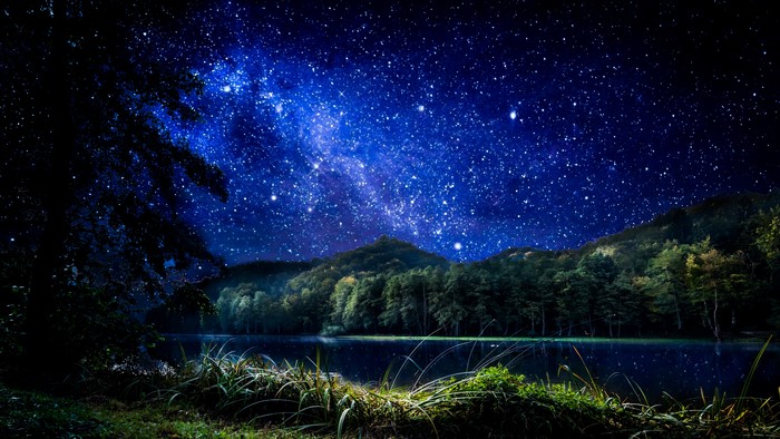 4K Milky Way over a lake and forest