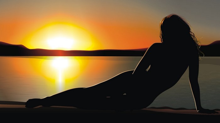 Silhouette of a woman by the lake at sunset