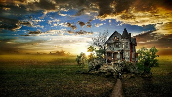 Old abandoned house on a rocky hill at sunset