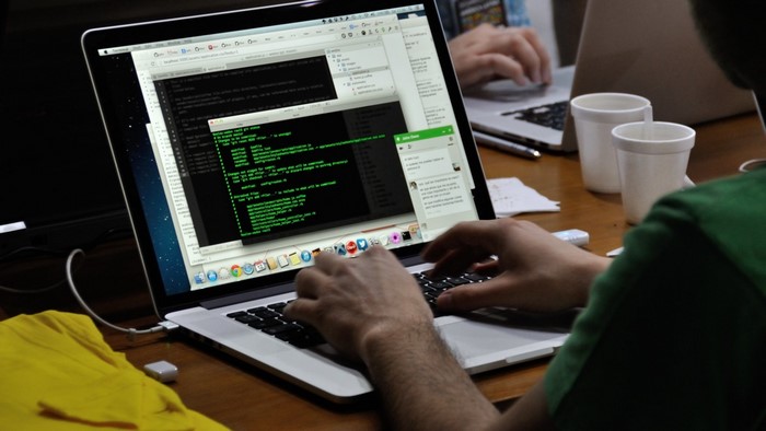 Person coding on a laptop with a chat window open