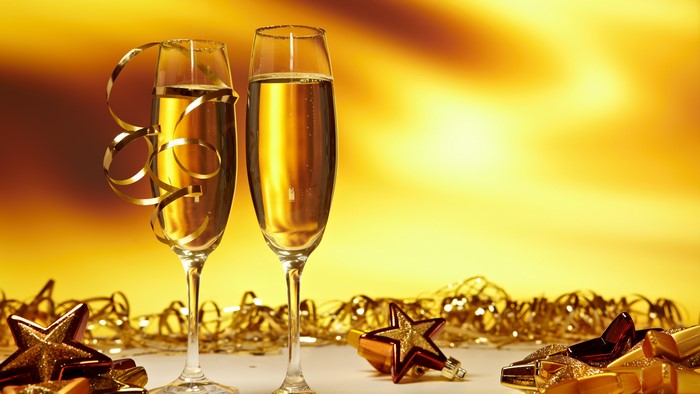 Two champagne glasses with gold ribbon and stars