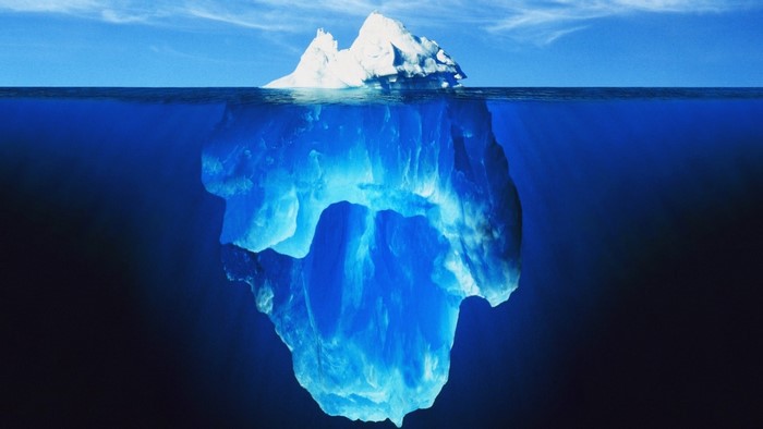 Iceberg underwater with blue water and sky