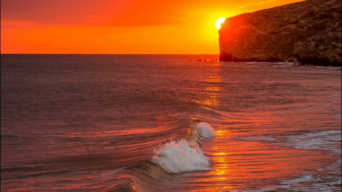 Sunset over the ocean with a cliff