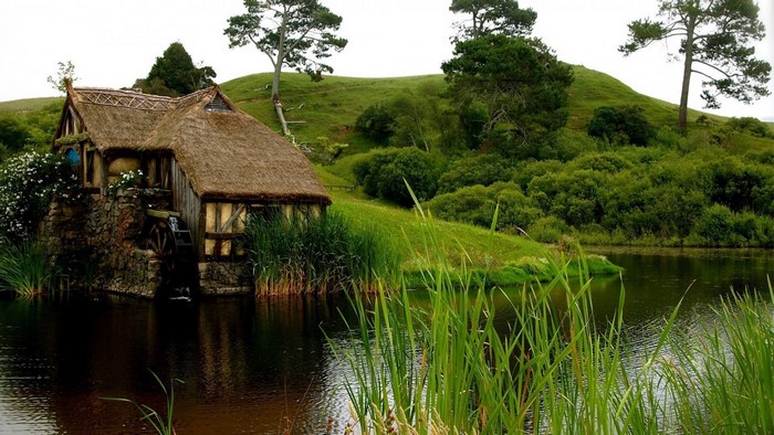 Old mill by a lake with rolling hills