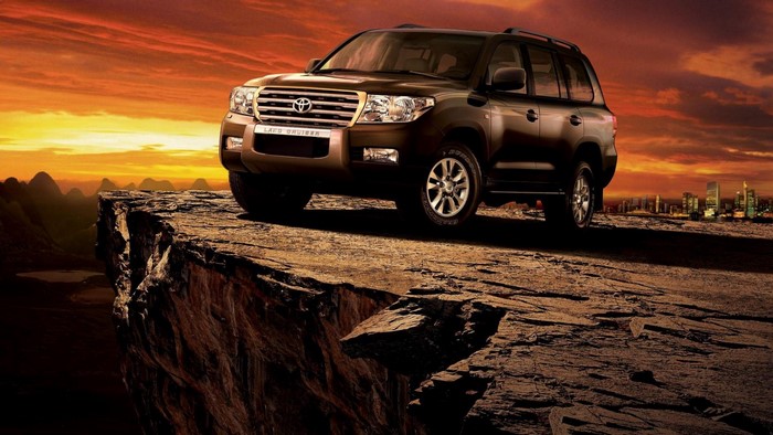 Toyota Land Cruiser on a cliff edge at sunset