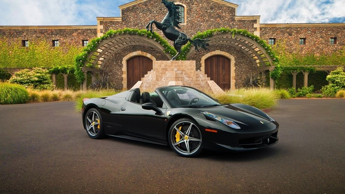 Black Ferrari 458 Spider in front of stone building