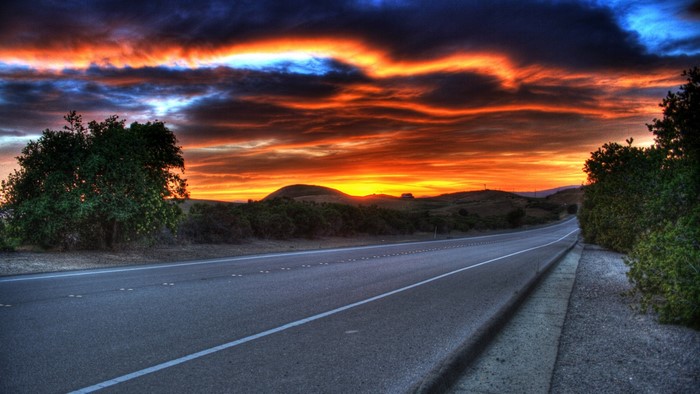 Road at sunset with dramatic clouds