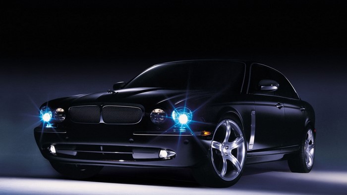 Black Jaguar car with headlights on
