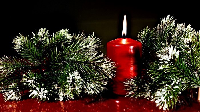 Red candle with pine branches
