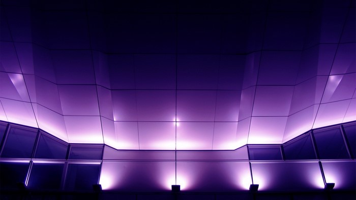 Modern building facade illuminated with purple lights