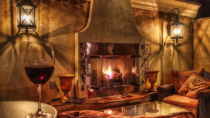 Cozy fireplace with a glass of red wine