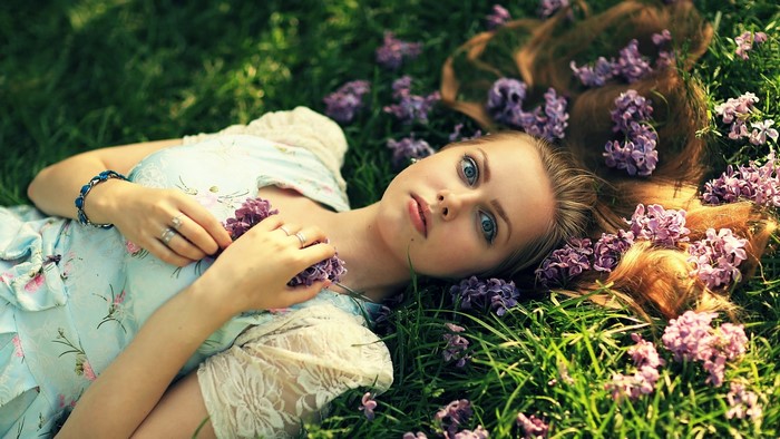 Girl lying in grass with flowers
