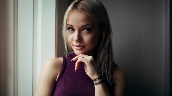 Young woman with blonde hair wearing a purple top