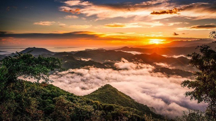 Sunset over misty mountains and ocean