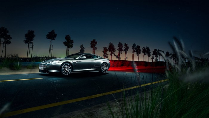 Aston Martin DB9 on a road at night