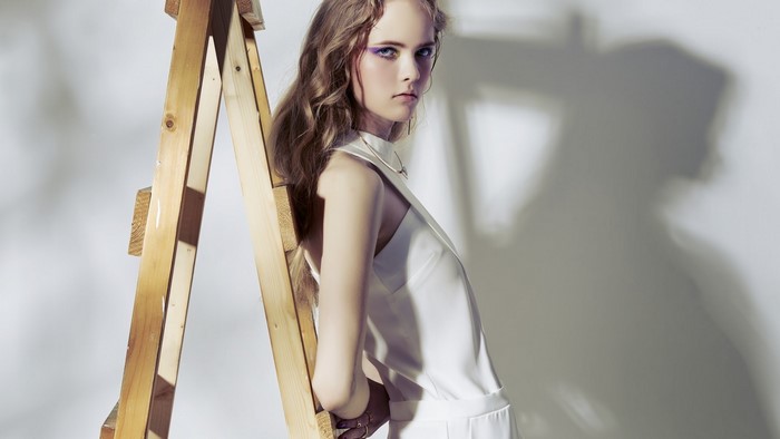 Girl leaning on a wooden ladder