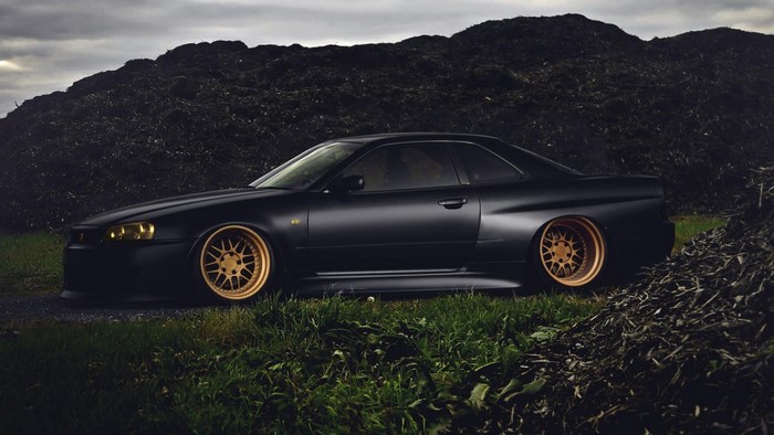 Matte black Nissan Skyline R34 with gold rims