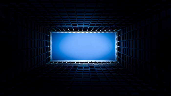 Looking up through a building structure at the blue sky