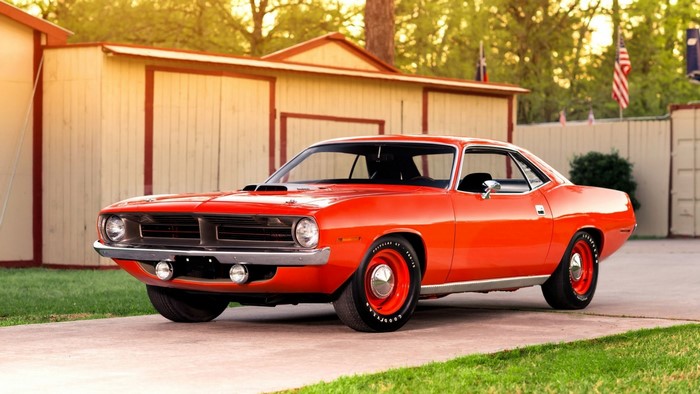 Orange 1970 Plymouth Barracuda parked outside a building