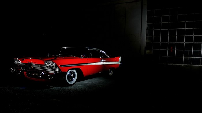 Red 1950s Plymouth Belvedere in a dark garage