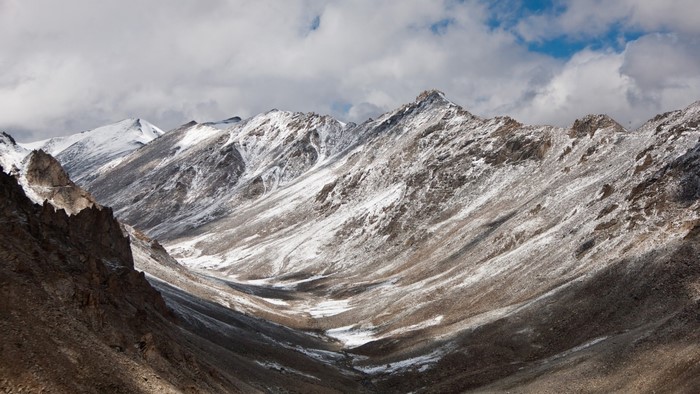 Snow-covered mountains under a cloudy sky
