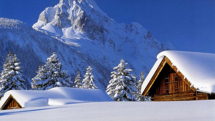 Snow-covered cabins in a mountain landscape