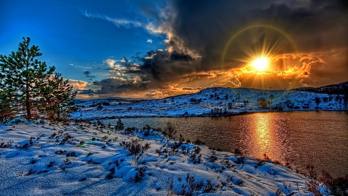 Sunset over a snow-covered lake and hills