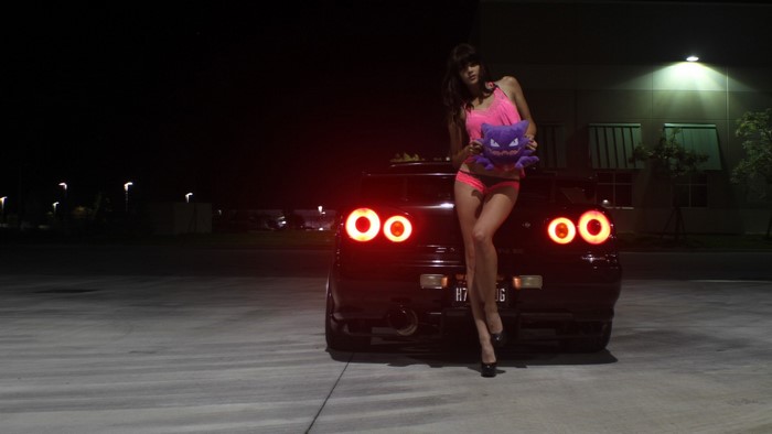 Woman with Pokemon plush by Nissan car at night