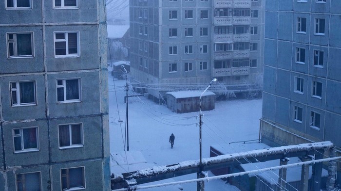 A person walks through a snowy courtyard in Yakutsk