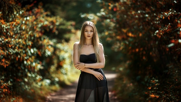 Woman in black dress in autumn forest