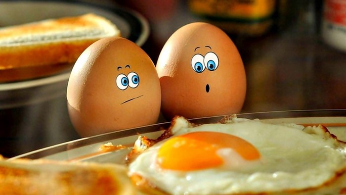 Funny eggs with faces and fried egg