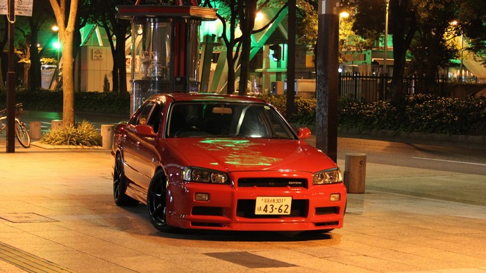 Red Nissan Skyline R34 GT-R parked at night