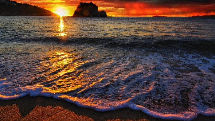Sunset over the ocean with a rocky island